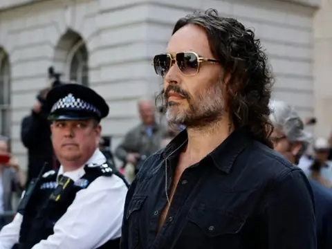 Comedian Russell Brand Faces Criminal Charges After Years of Allegations